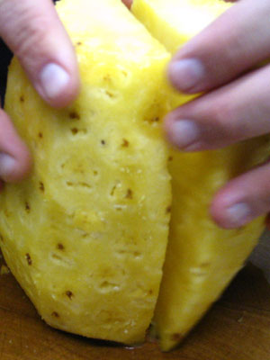 Cut Pineapple Into Two. Cut Pineapple Along The Center and Parallel. Split Into Two When Cut Is Complete. (22k)